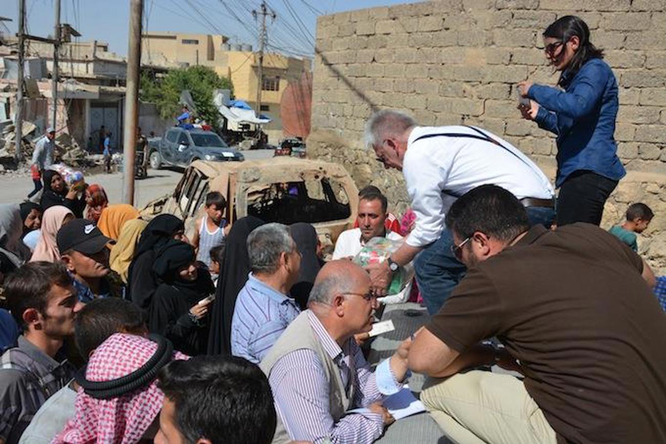 Bildlegende: CSI-Mitarbeiter John Eibner koordiniert die Verteilung der Lebensmittel in der zerstörten Stadt, Foto Hammurabi