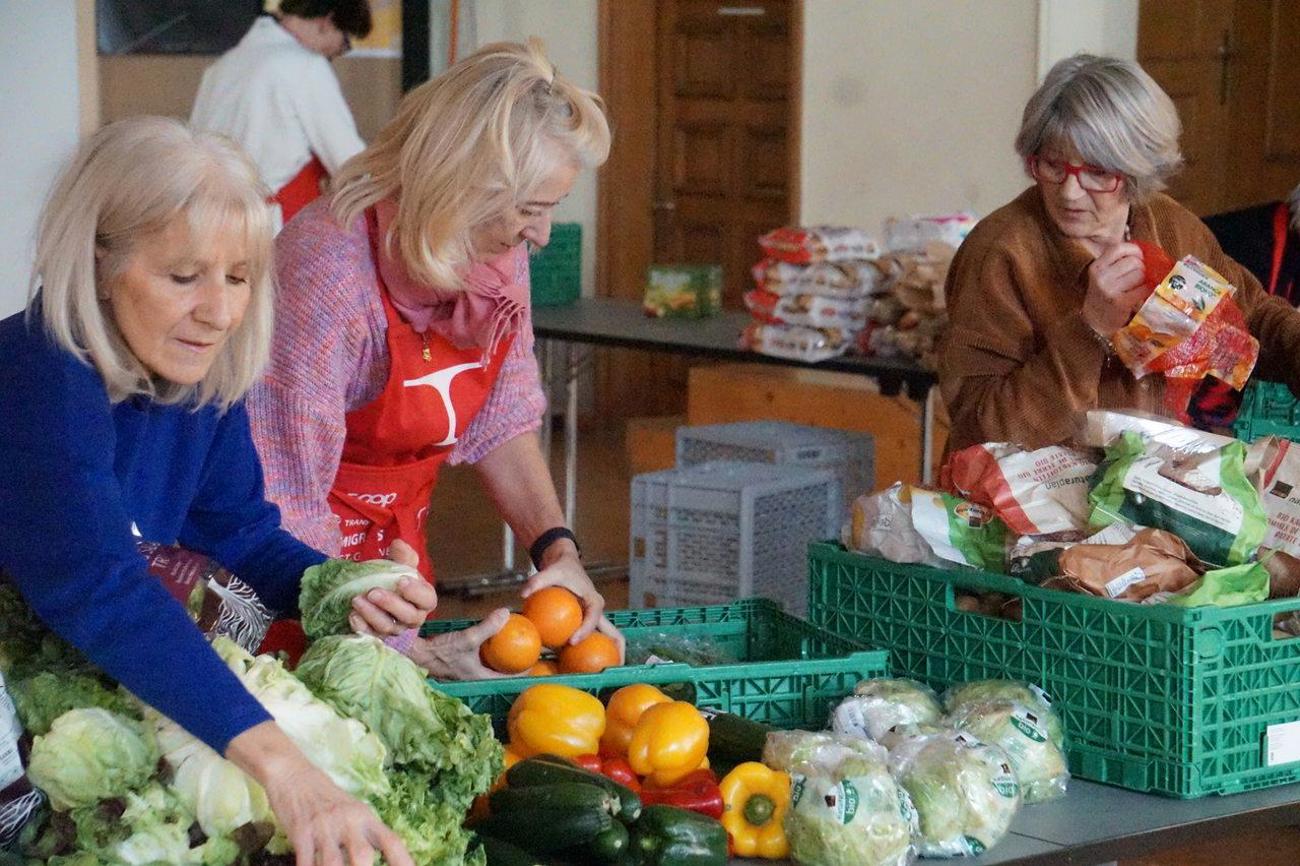 Freiwillige Mitarbeiterinnen sortieren Gemüse, …