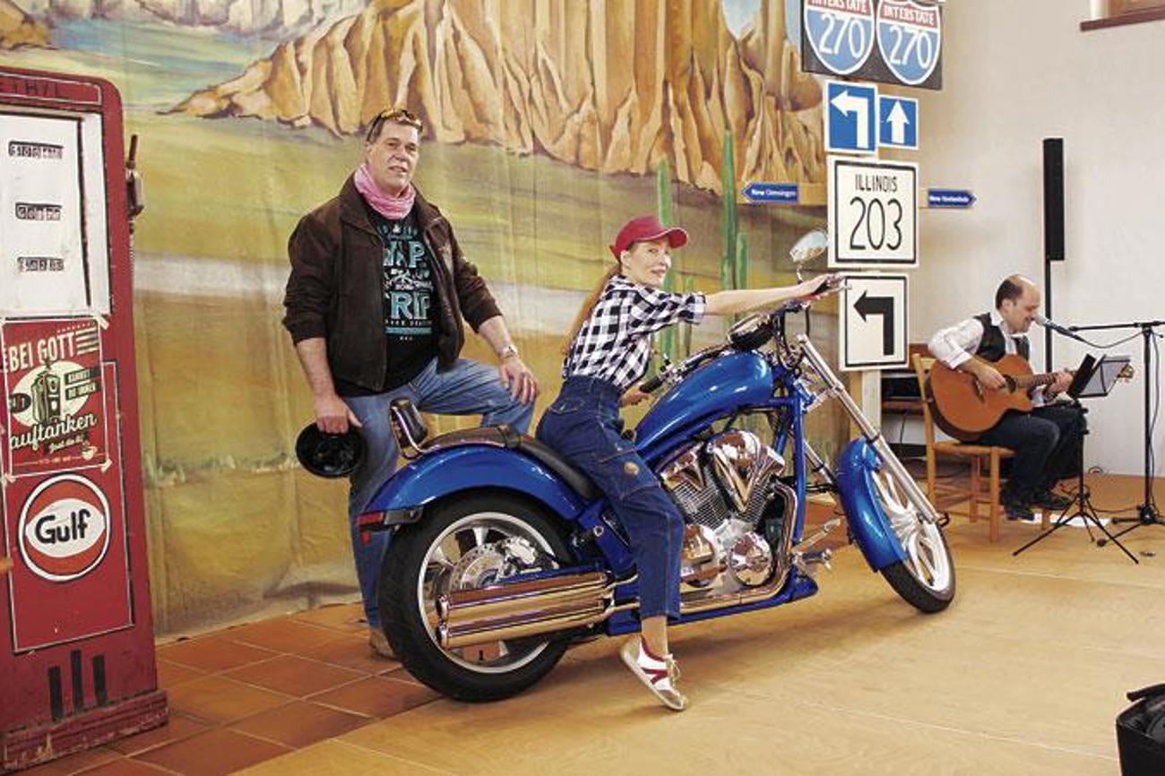 Wildwest-Kulise und Harley: Pfarrerin Yvonne Gütiger und Diakon Urs Wieland im Motorradgottesdienst.