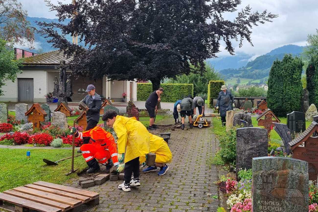 Pflastersteine ausheben und abspritzen — die gemeinsame Arbeit verbindet. Foto: zvg