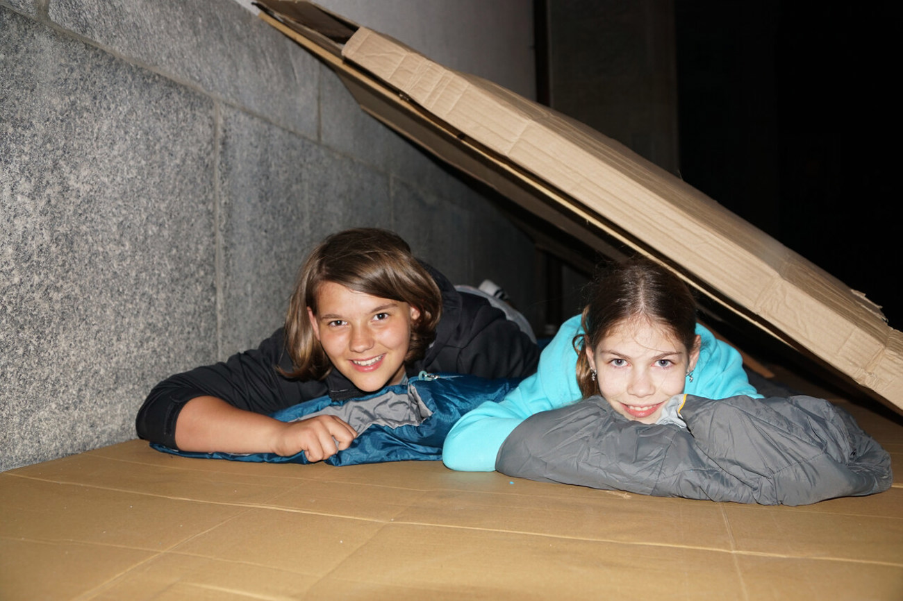 Jolina (links) und Elin haben es sich zwischen Kirchenwand und Karton gemütlich gemacht. Foto: Andrea Kobler
