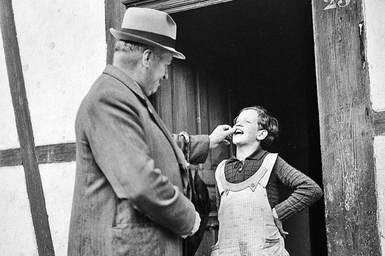 Zahnkontrolle bei einem Verdingmädchen durch den Armeninspektor 1940. | Paul Senn, FFV, Kunstmuseum Bern