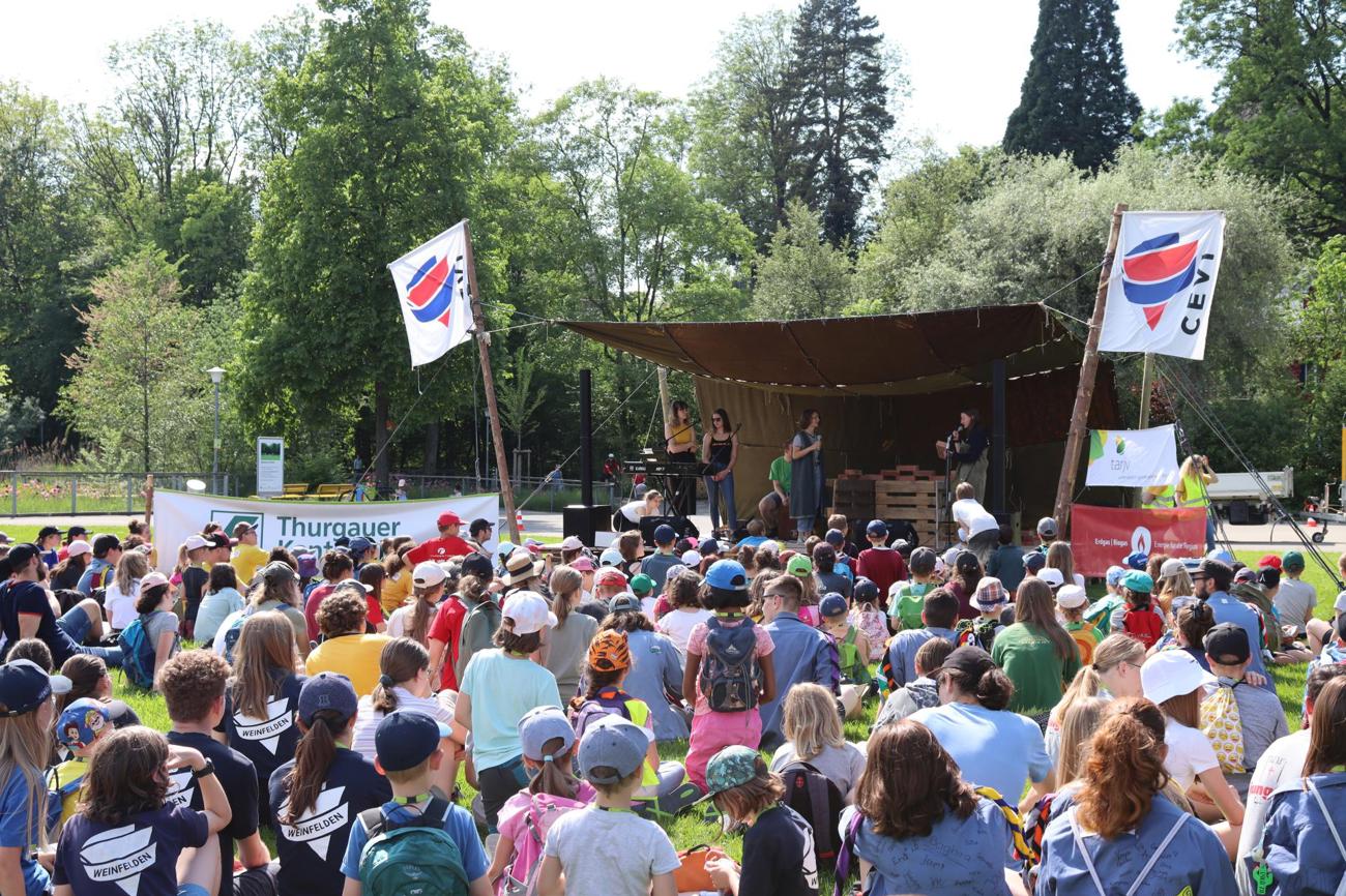 Die knapp 400 Teilnehmenden lauschen dem Theater auf der Bühne.