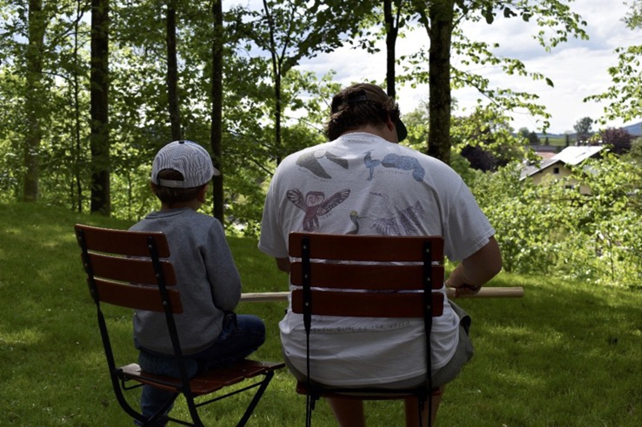 Vater und Sohn schnitzen einen Pfeilbogen. Foto: Rahel Steiger