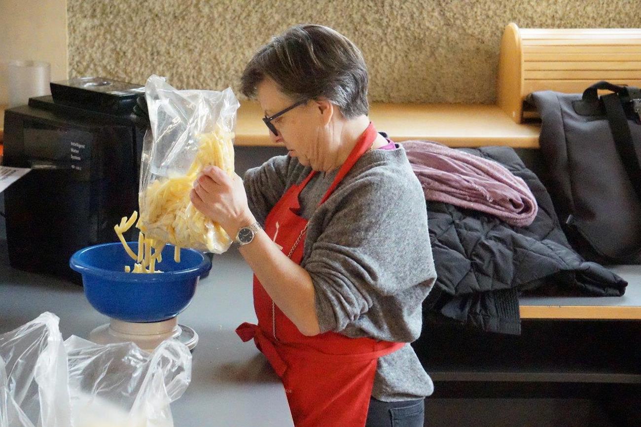 Annina Policante wägt in der Offenen Kirche Tiefkühl-Pommes-frites ab und verpackt die Portionen in Säcke. Die Kartoffelstäbchen wurden von Grossverteilern wie zum Beispiel Migros und Coop, Aldi, Lidl und Prodega ausgemustert und werden von Freiwilligen an Bedürftige verteilt. Foto: sd