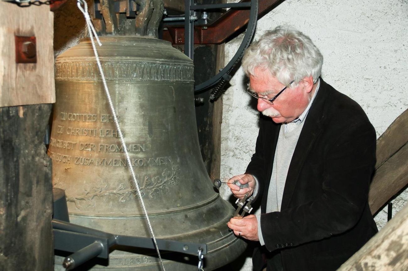 Glockenexperte Hans Jürg Gnehm aus Affeltrangen bestimmt mit der Stimmgabel den Klang einer Glocke im Hüttlinger Kirchturm. (Bilder: Claudia Koch)