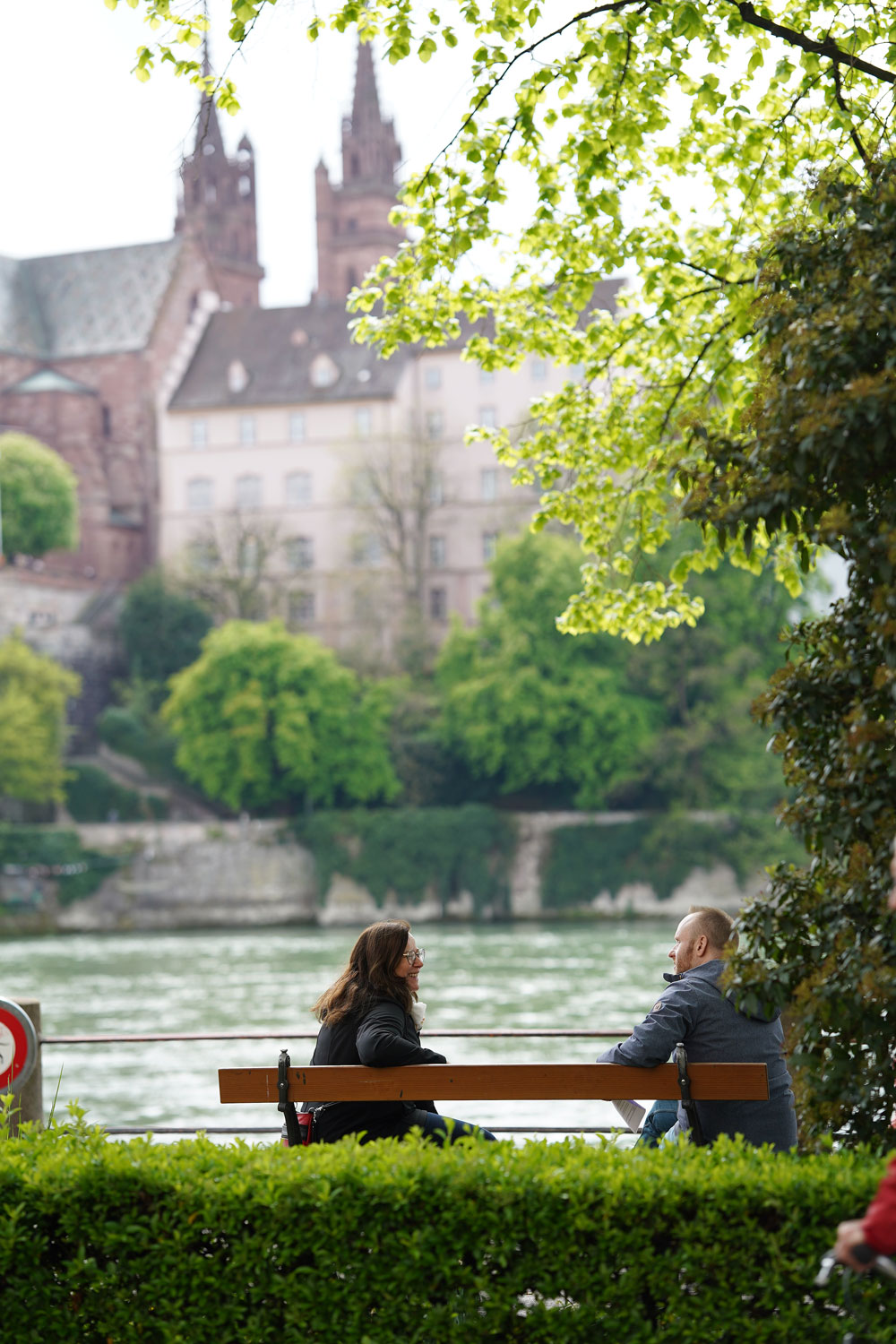 Monika Widmer und Michael Schäppi sitzen zum Abschluss auf einer Bank am Rhein und unterhalten sich.