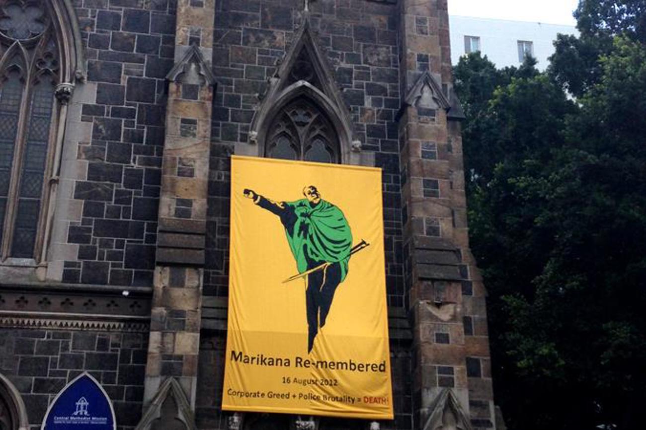 An der Kirche am Green Market Square im südafrikanischen Kapstadt erinnert ein Banner an die 34 Minenarbeiter, die vor vier Jahren in Marikana während einer Demonstration erschossen wurden. | wikimedia commons/Discott