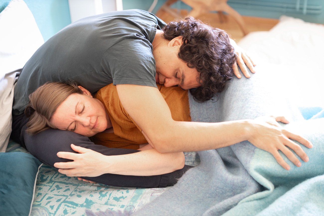 Tina und Therapeut Ruben demonstrieren im Berliner «Kuschelraum» den «Kokon». Eine von 32 Positionen, in denen sich zum Teil wildfremde Menschen aneinanderschmiegen. | Foto: epd/Hans Scherhaufer