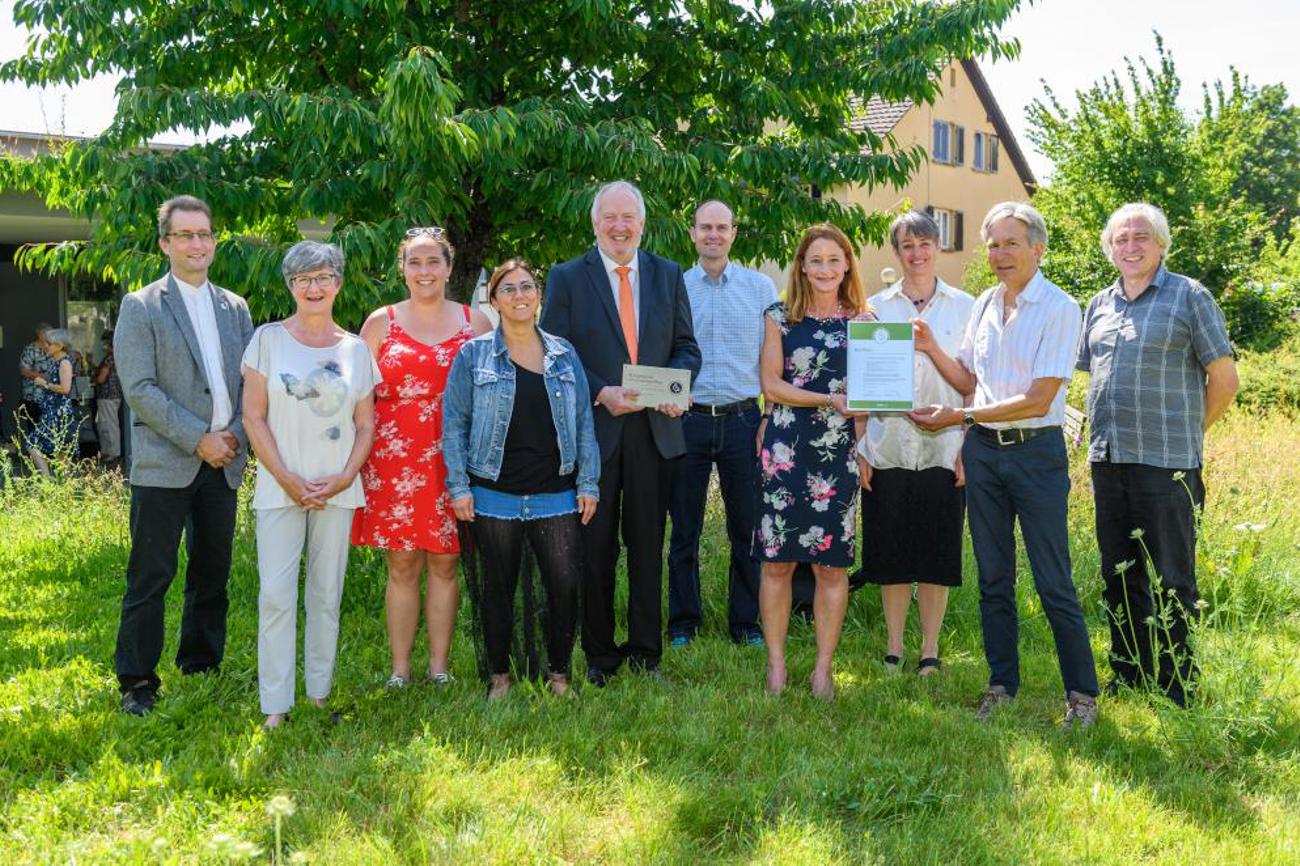 Kurt Zaugg-Ott von der «oeku» überreicht dem Buchthaler Umweltteam das Zertifikat «Grüner Güggel» | Mike Kessler